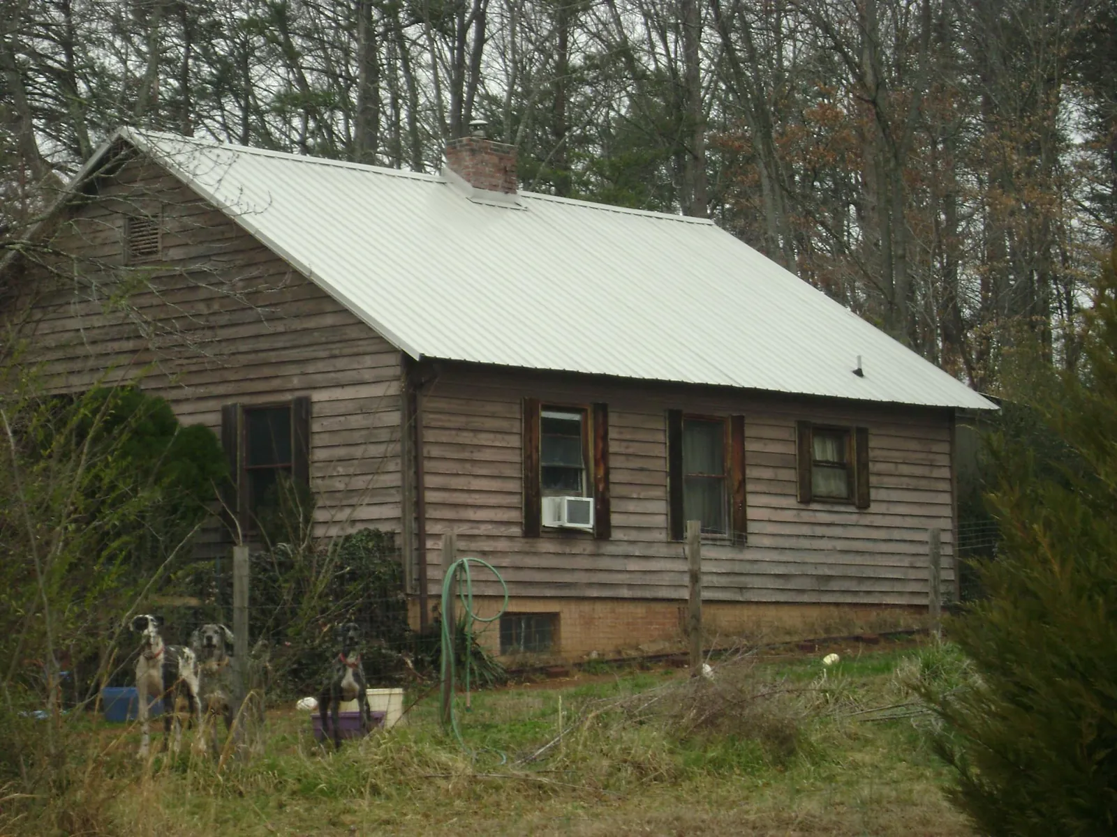 White metal roof on an old wood sided farmhouse, from a Asphalt Shingle Roof Repair job in Springtown